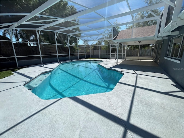 view of pool with glass enclosure, fence, a fenced in pool, and a patio area