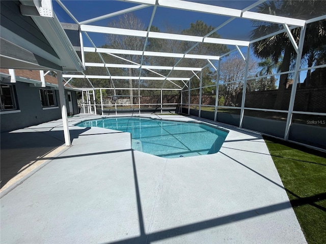 pool with a patio area and glass enclosure