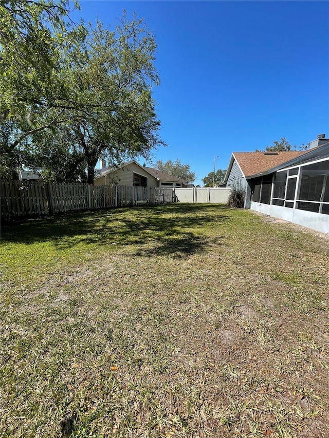 view of yard with a fenced backyard and a sunroom