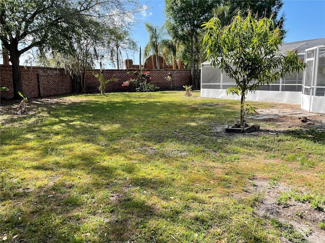 view of yard with a fenced backyard and a sunroom