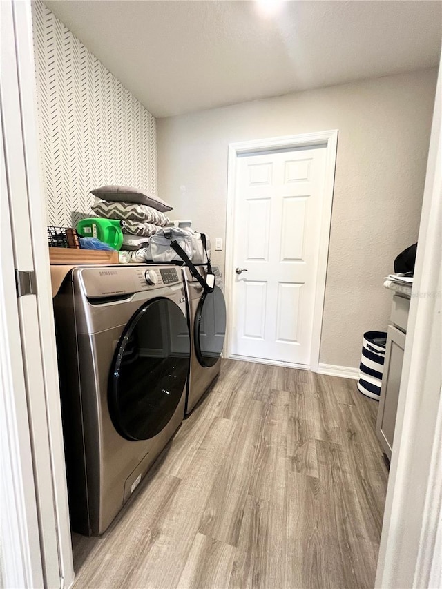 clothes washing area with light hardwood / wood-style flooring and independent washer and dryer