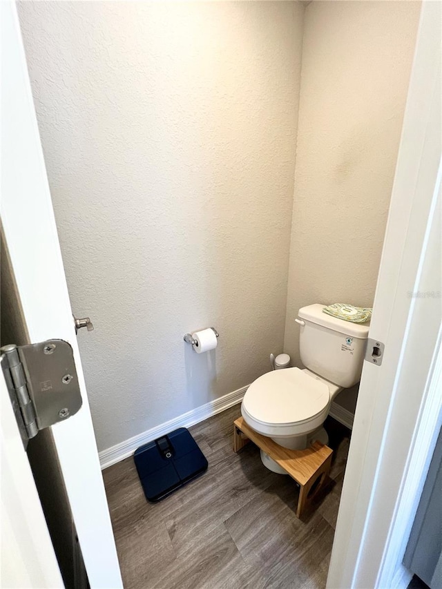 bathroom featuring toilet and wood-type flooring