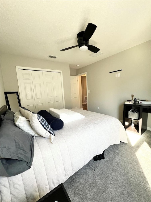 carpeted bedroom with ceiling fan and a closet