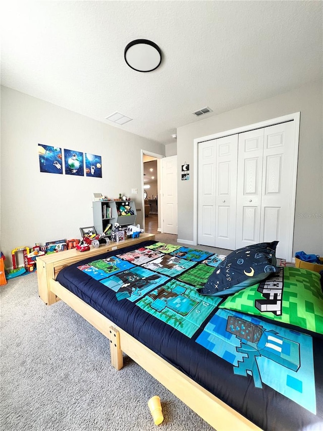 carpeted bedroom featuring a textured ceiling and a closet