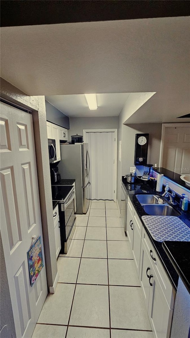 kitchen featuring electric stove, white cabinetry, sink, and light tile patterned flooring