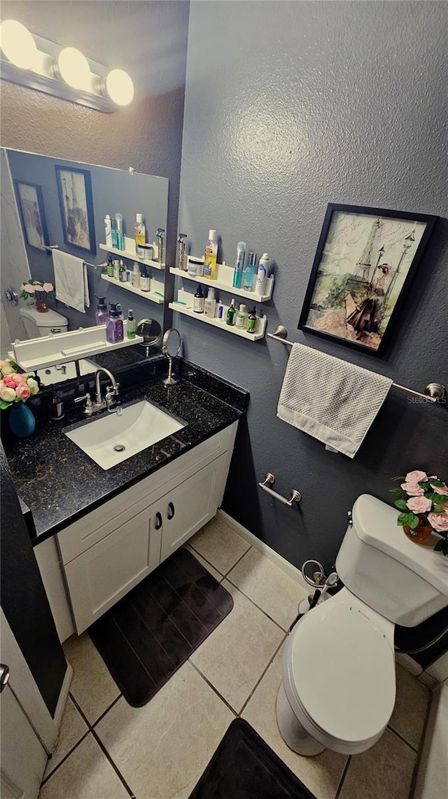 bathroom featuring tile patterned flooring, vanity, and toilet