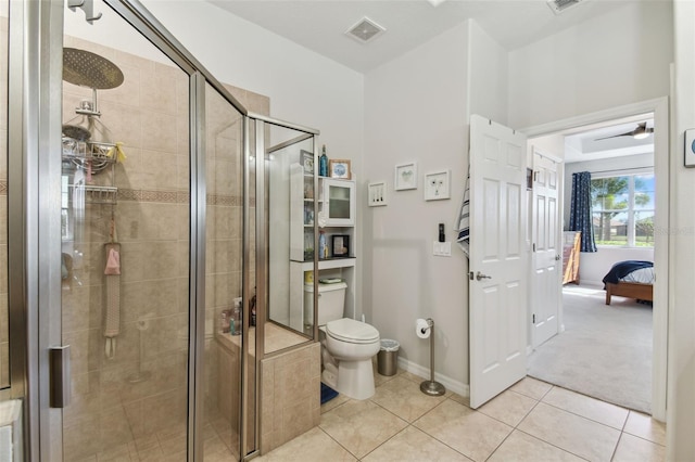 bathroom with toilet, tile patterned flooring, and a shower with shower door