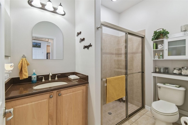 bathroom featuring a shower with door, tile patterned flooring, vanity, and toilet