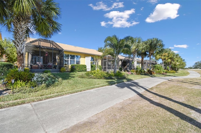 view of front of property with a front yard and glass enclosure