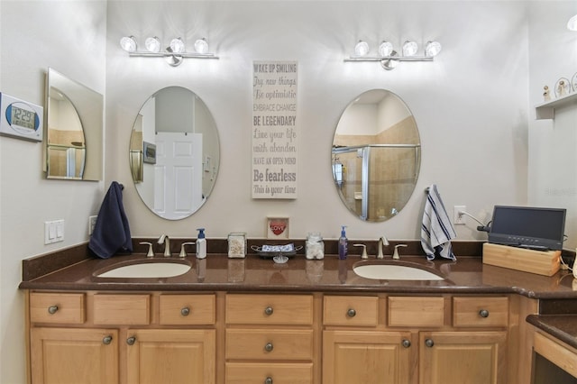 bathroom featuring a shower with shower door and vanity