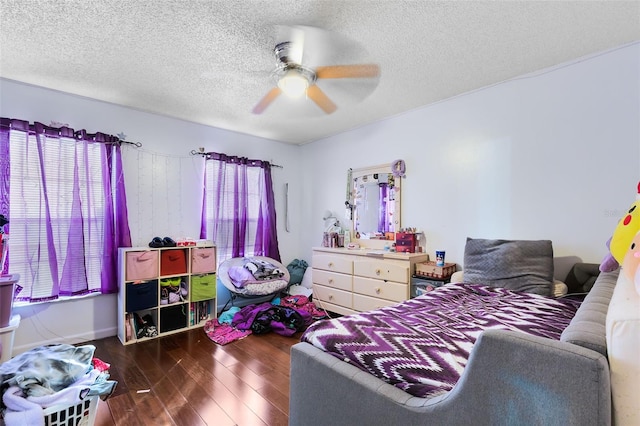 bedroom with dark hardwood / wood-style flooring, a textured ceiling, and ceiling fan