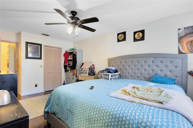 bedroom featuring wood-type flooring, a closet, ceiling fan, and a textured ceiling