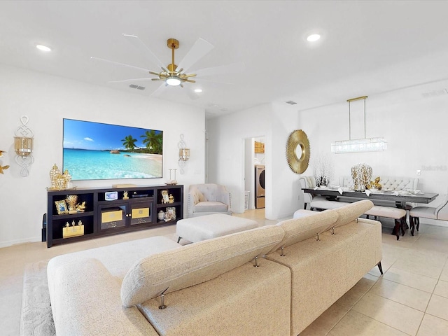 living room with tile patterned flooring, washer / clothes dryer, and ceiling fan