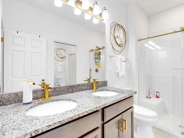 bathroom featuring tile patterned flooring, vanity, toilet, and a shower with door