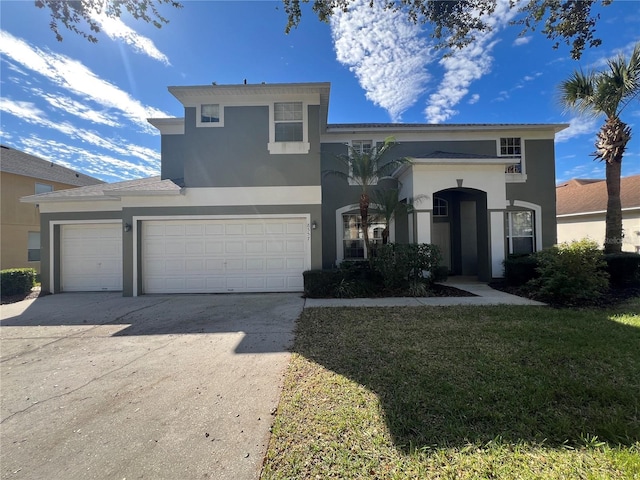 view of front of property with a garage, a front lawn, concrete driveway, and stucco siding