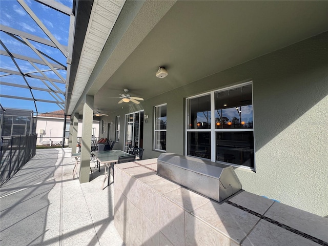 view of patio / terrace with ceiling fan and a lanai