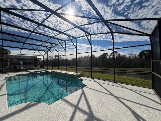 view of swimming pool featuring glass enclosure, a pool with connected hot tub, and a patio