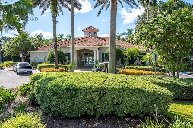 view of front of property featuring french doors, a tile roof, and stucco siding