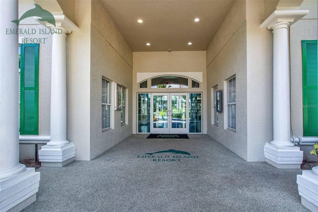 property entrance featuring stucco siding and french doors