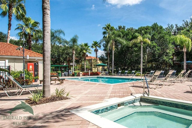 pool with a community hot tub, a patio, and fence