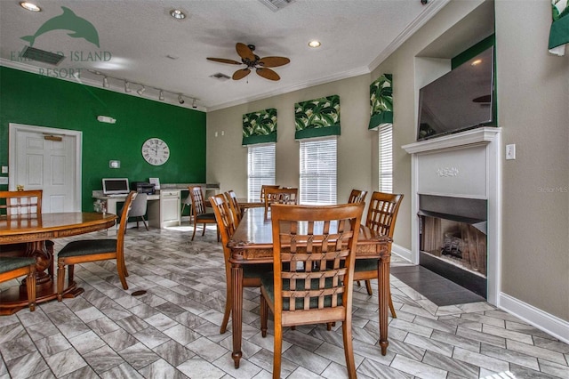 dining space featuring a textured ceiling, ornamental molding, a fireplace, and visible vents