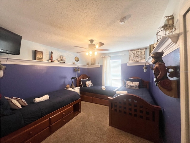 bedroom featuring a ceiling fan, carpet, and a textured ceiling