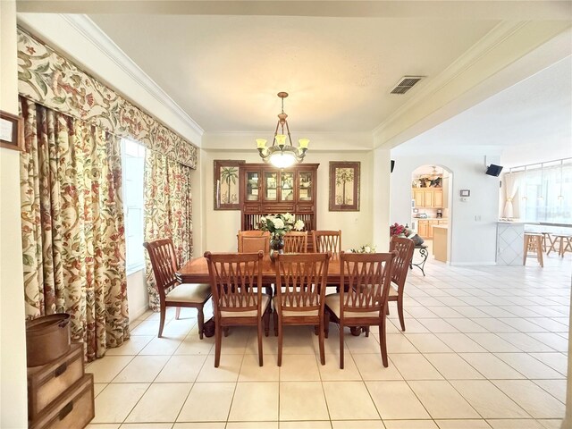8557 La Isla Dr, Kissimmee, FL 34747 - dining area with a chandelier, light tile patterned floors, ornamental molding, and plenty of natural light