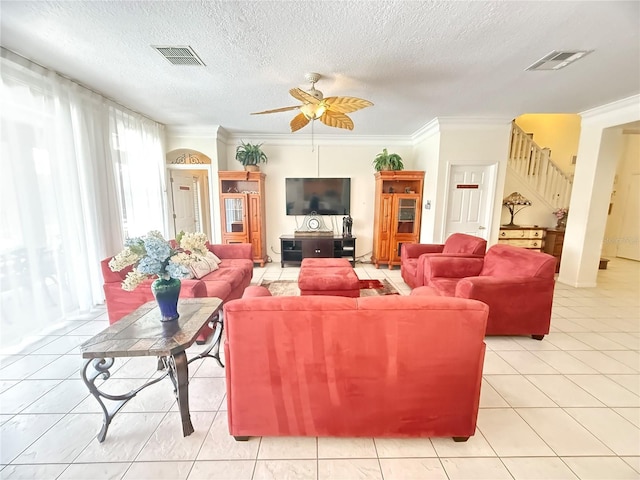8557 La Isla Dr, Kissimmee, FL 34747 - living room with ceiling fan, crown molding, stairway, a textured ceiling, and light tile patterned floors
