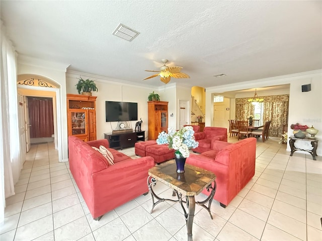 8557 La Isla Dr, Kissimmee, FL 34747 - living area with light tile patterned floors, crown molding, ceiling fan, a textured ceiling, and arched walkways