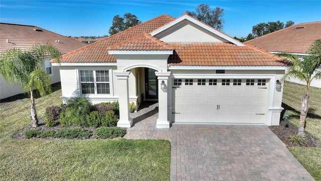 mediterranean / spanish-style house featuring a front lawn and a garage