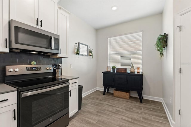 kitchen featuring decorative backsplash, white cabinetry, and appliances with stainless steel finishes