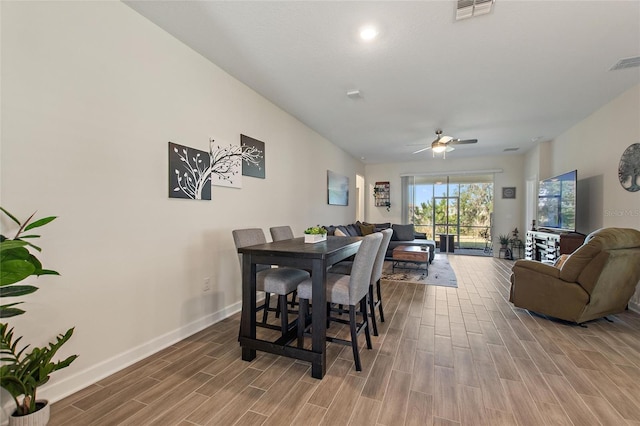 dining area with ceiling fan and wood-type flooring