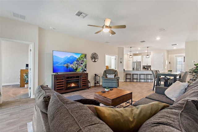 living room with light wood-type flooring and ceiling fan