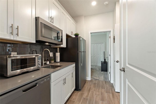 kitchen featuring decorative backsplash, sink, white cabinets, and stainless steel appliances