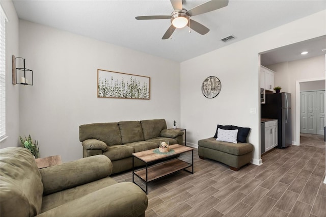 living room featuring ceiling fan and light hardwood / wood-style floors