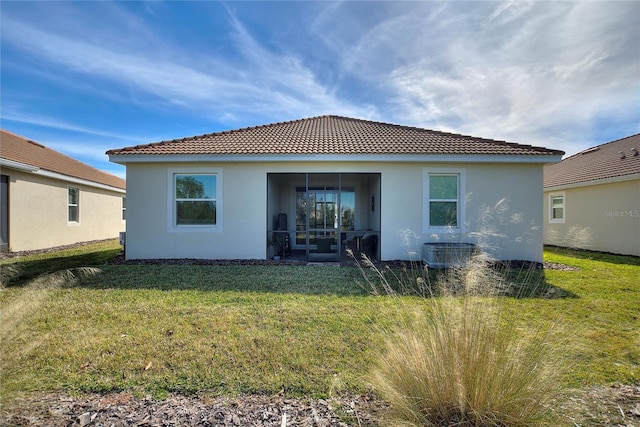 back of house with central AC unit and a yard