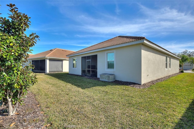 back of property featuring a sunroom and a yard