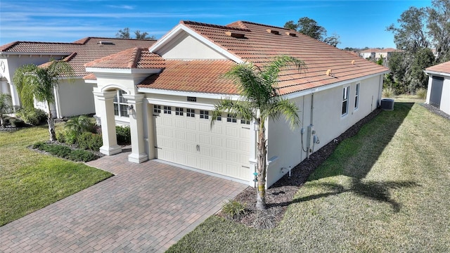 view of home's exterior featuring a lawn, cooling unit, and a garage