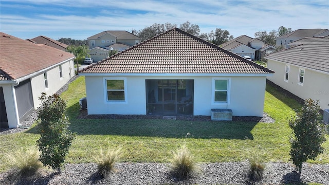 back of property featuring a lawn and central air condition unit