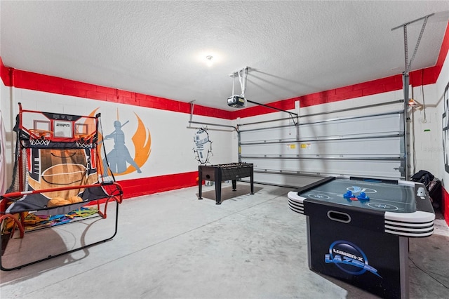 playroom featuring concrete flooring and a textured ceiling