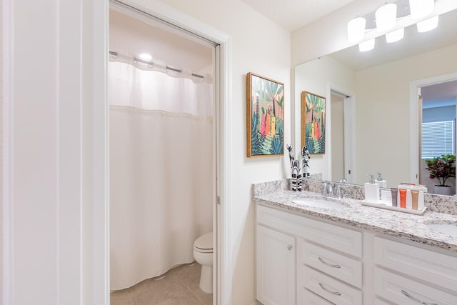 bathroom featuring tile patterned flooring, vanity, and toilet