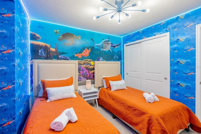 carpeted bedroom with a closet, a chandelier, and a textured ceiling