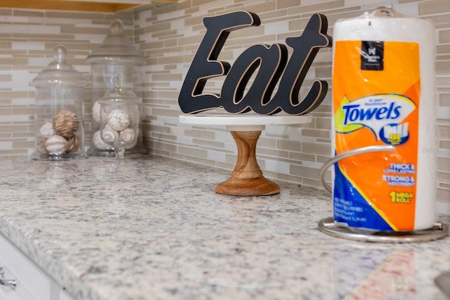 room details with light stone countertops and backsplash