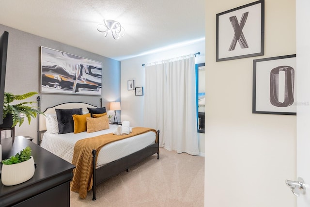 bedroom with a textured ceiling and light colored carpet