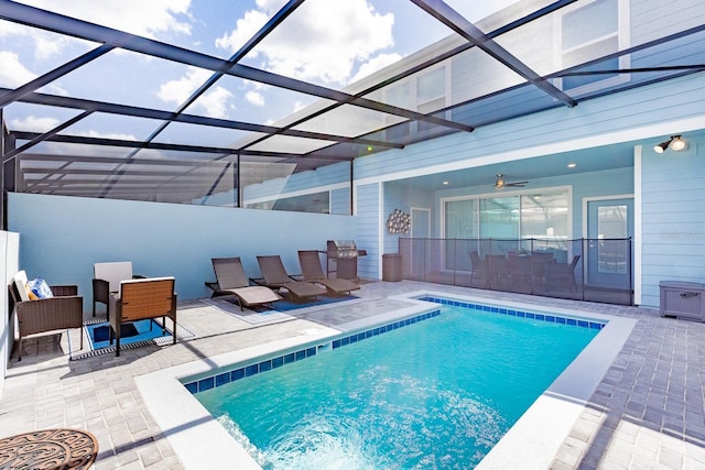 view of swimming pool featuring ceiling fan, a patio, and glass enclosure