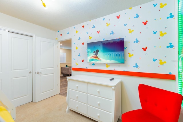 bedroom featuring light colored carpet and a closet