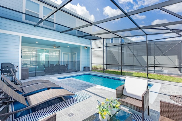 view of swimming pool featuring ceiling fan, a patio area, and glass enclosure