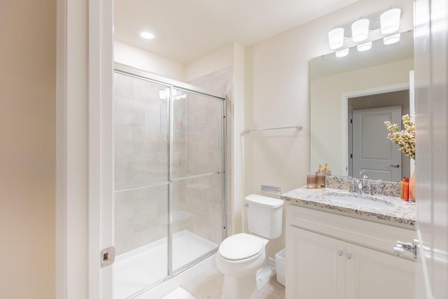 bathroom featuring tile patterned flooring, vanity, toilet, and an enclosed shower