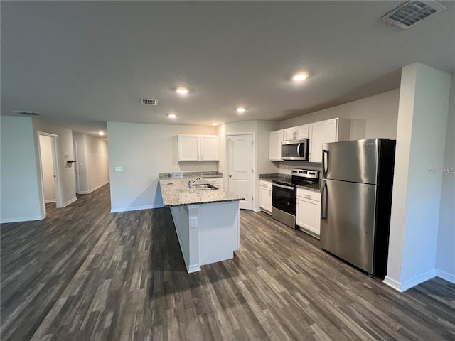 kitchen with light stone countertops, sink, stainless steel appliances, dark hardwood / wood-style floors, and white cabinets