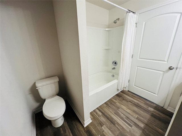 bathroom with shower / bath combo with shower curtain, hardwood / wood-style floors, and toilet